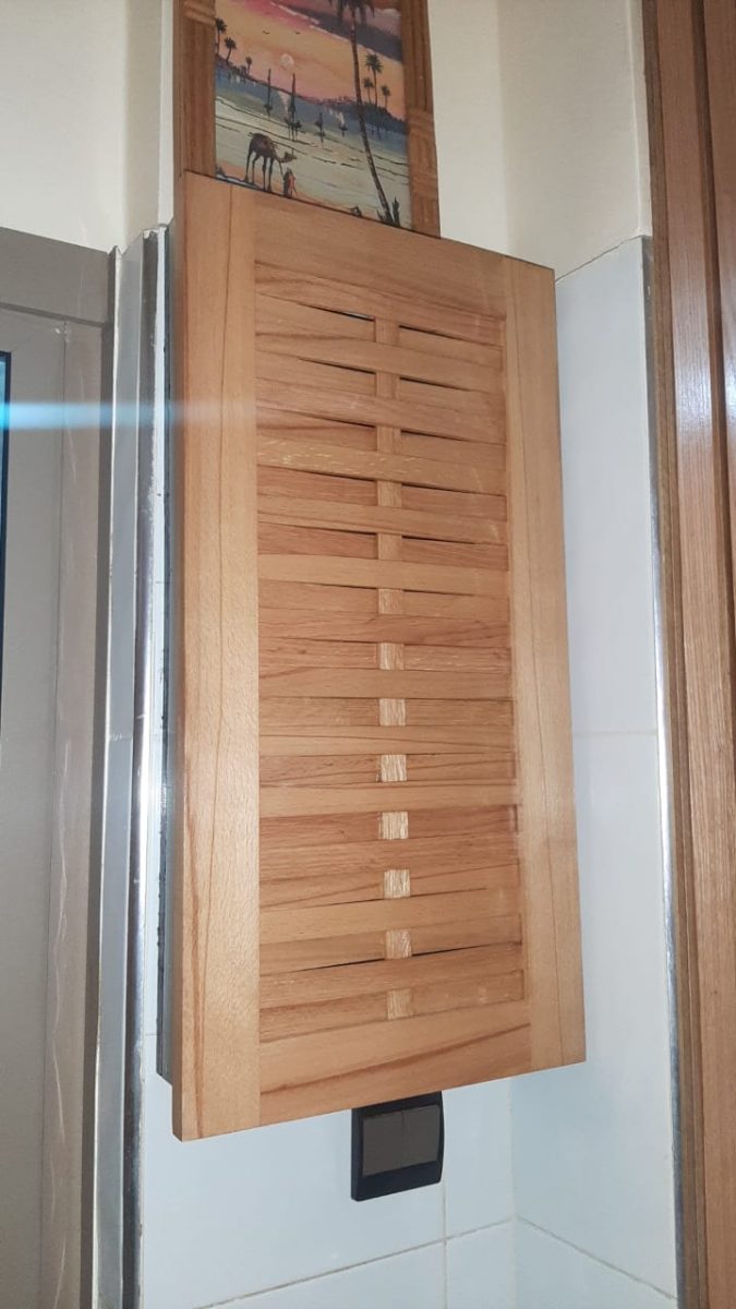 Cache en bois à lamelles ajourées monté au mur
