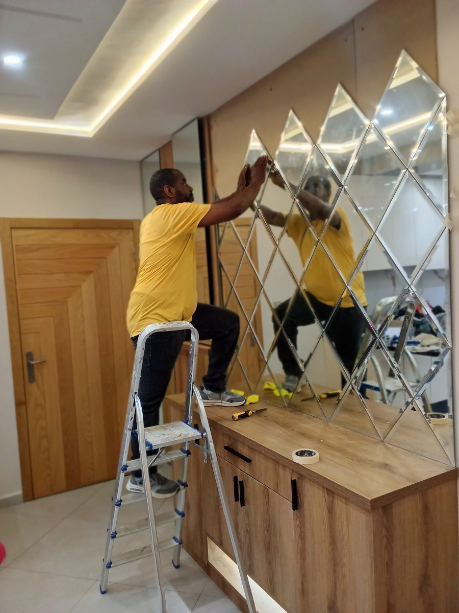 Pose d'un mur de miroirs en losanges biseautés au-dessus d'une console