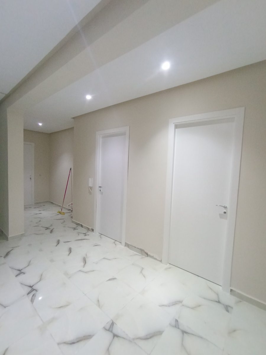 Couloir peint beige et taupe à faux plafond à décrochés