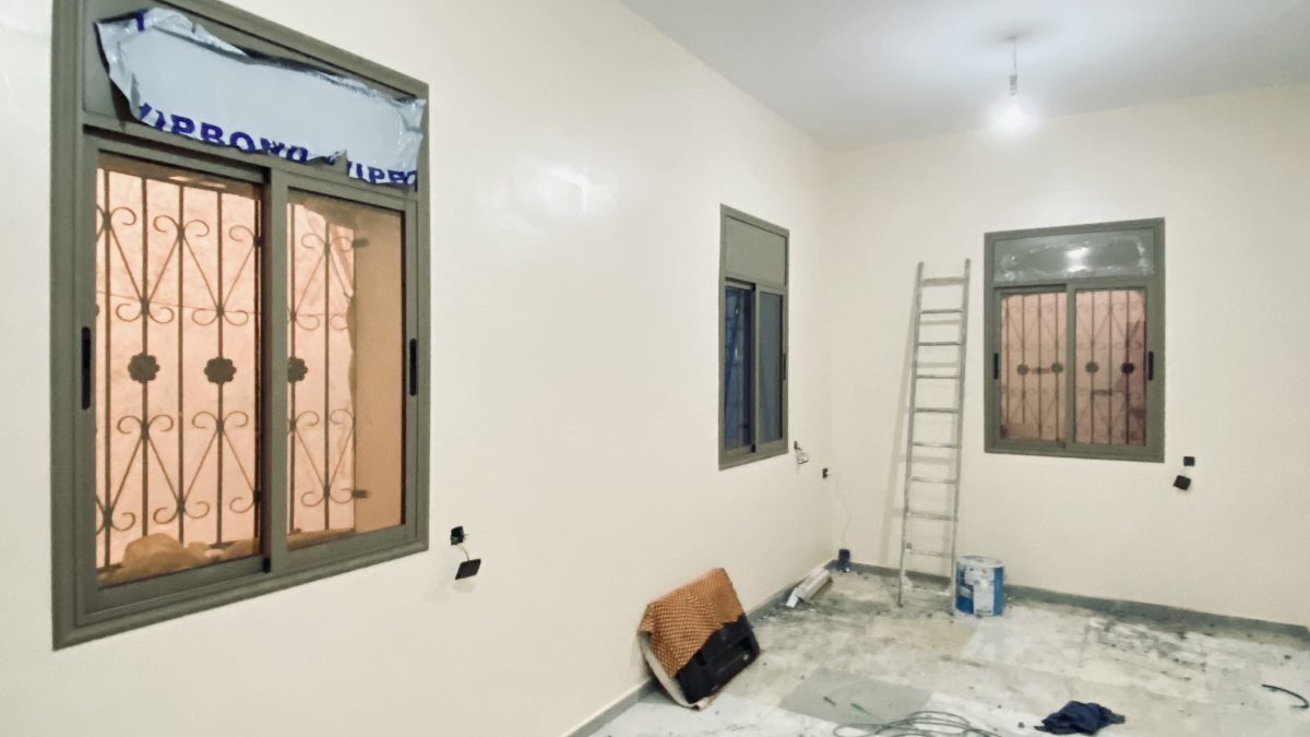 Chambre à fenêtres coulissantes en aluminium gris et grilles, en cours