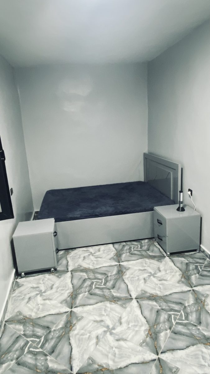 Chambre à lit coffre gris et sol carrelé effet marbre étoilé