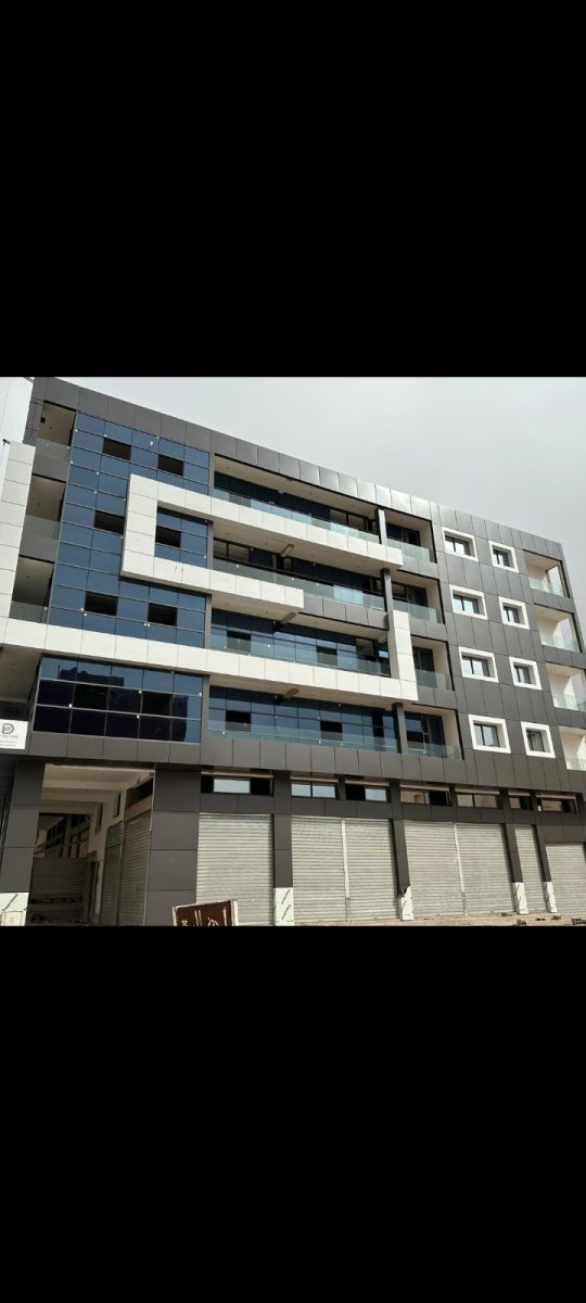 Façade d'immeuble en cladding gris avec baies et garde-corps en aluminium