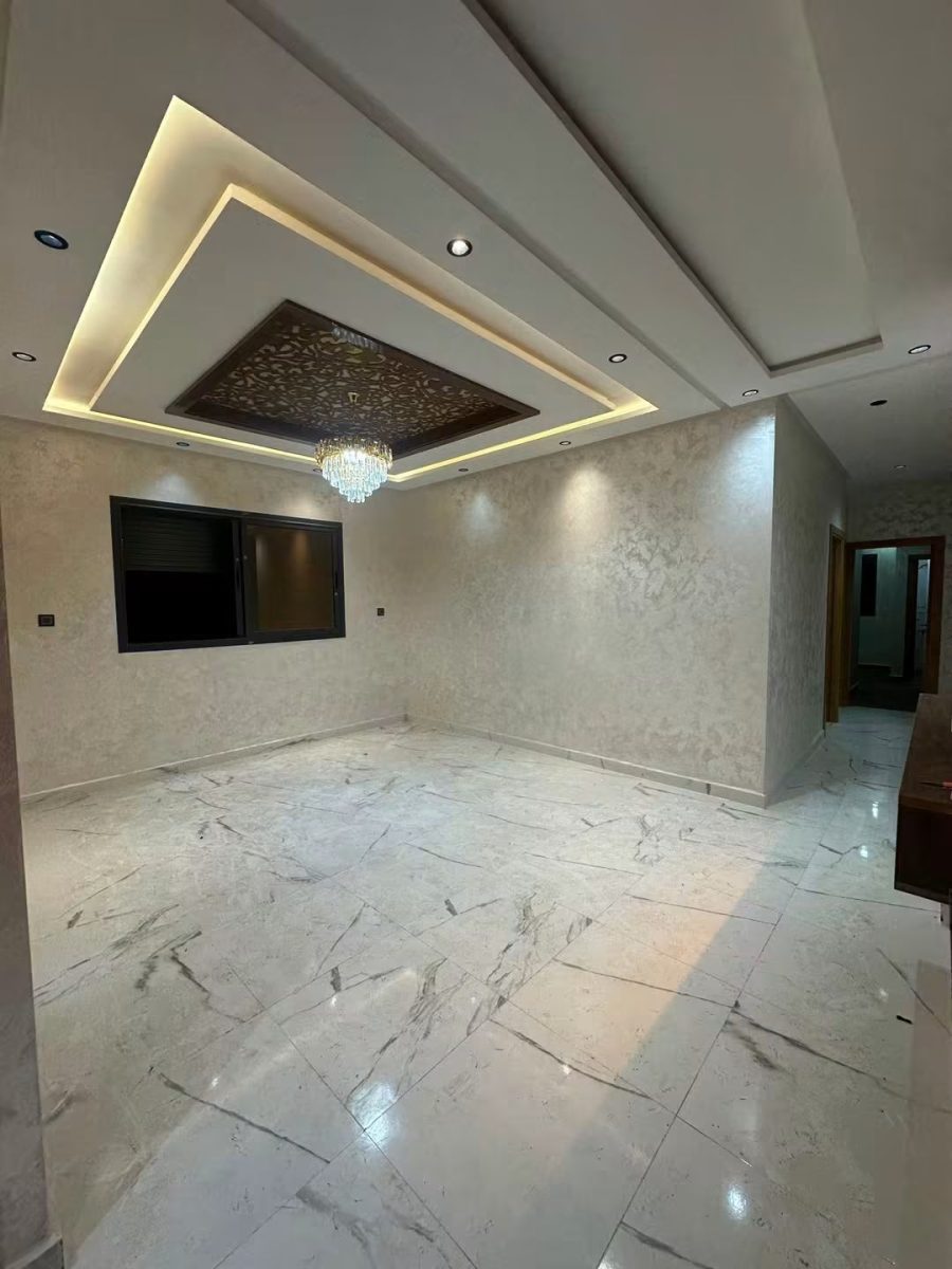Salon avec faux plafond lumineux, panneau ajouré et lustre