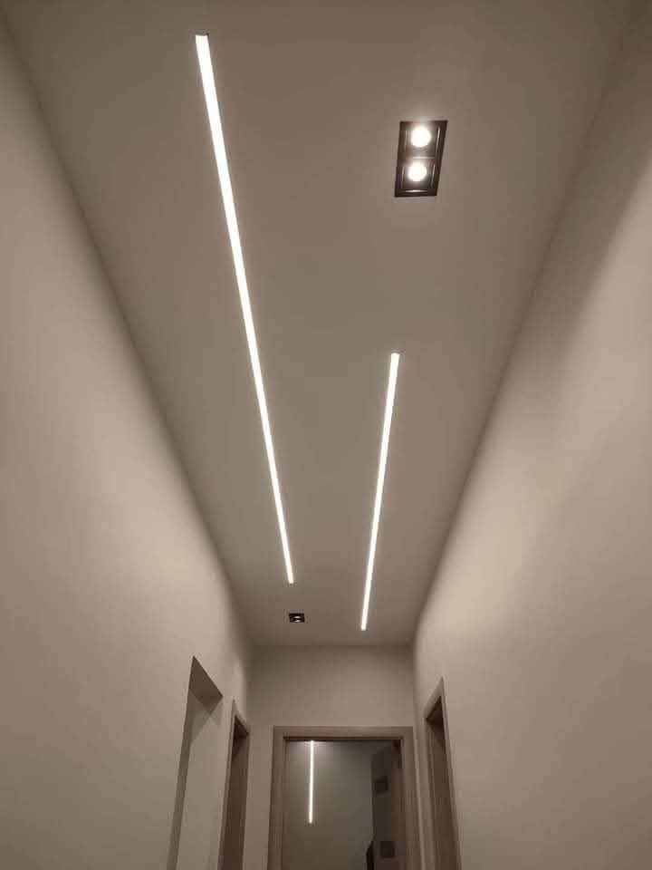 Couloir avec bandes lumineuses LED linéaires encastrées au plafond