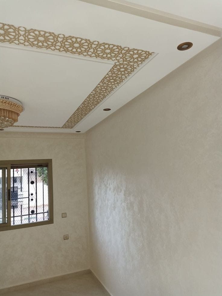 Pièce avec peinture décorative beige et faux plafond à frise arabesque