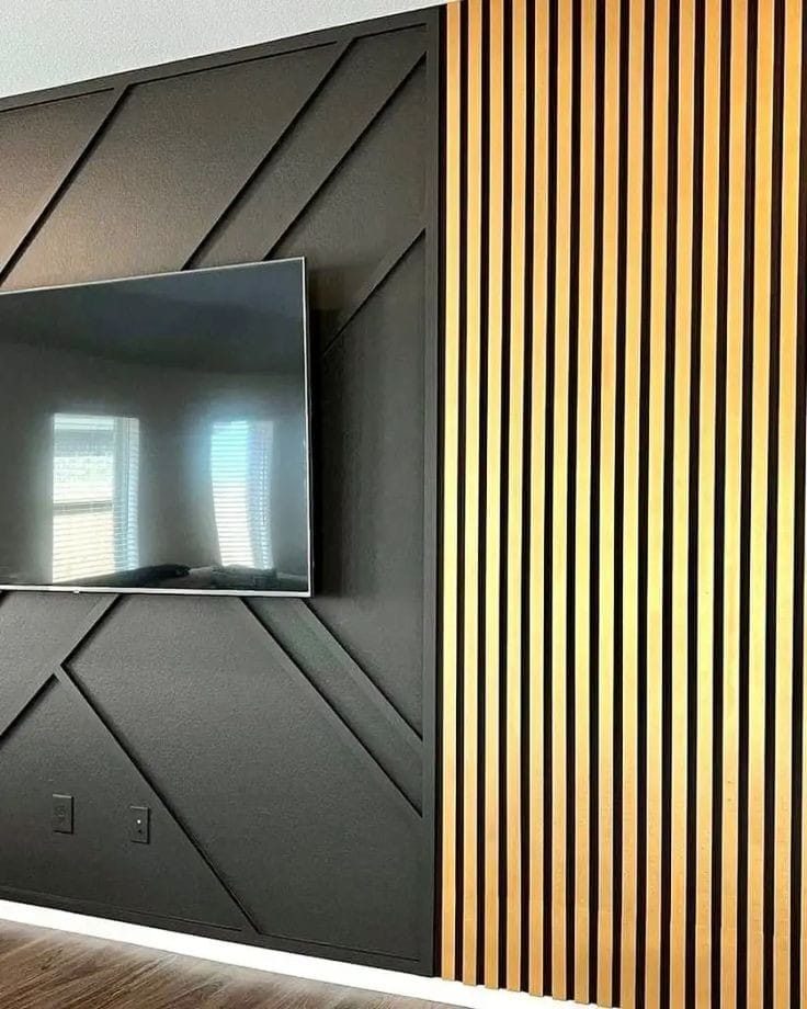 Habillage mural avec panneau géométrique noir et tasseaux de bois, TV encastrée