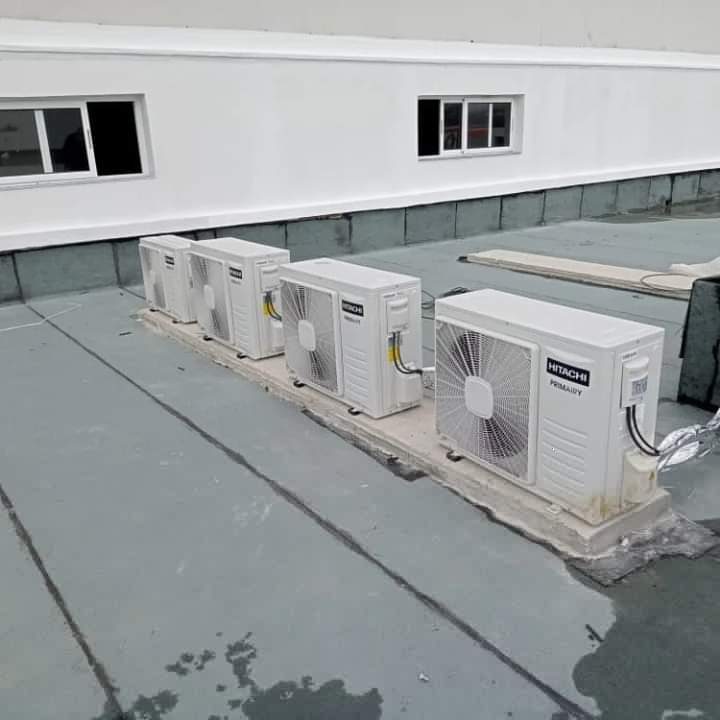 Quatre groupes extérieurs de climatisation Hitachi alignés sur une toiture