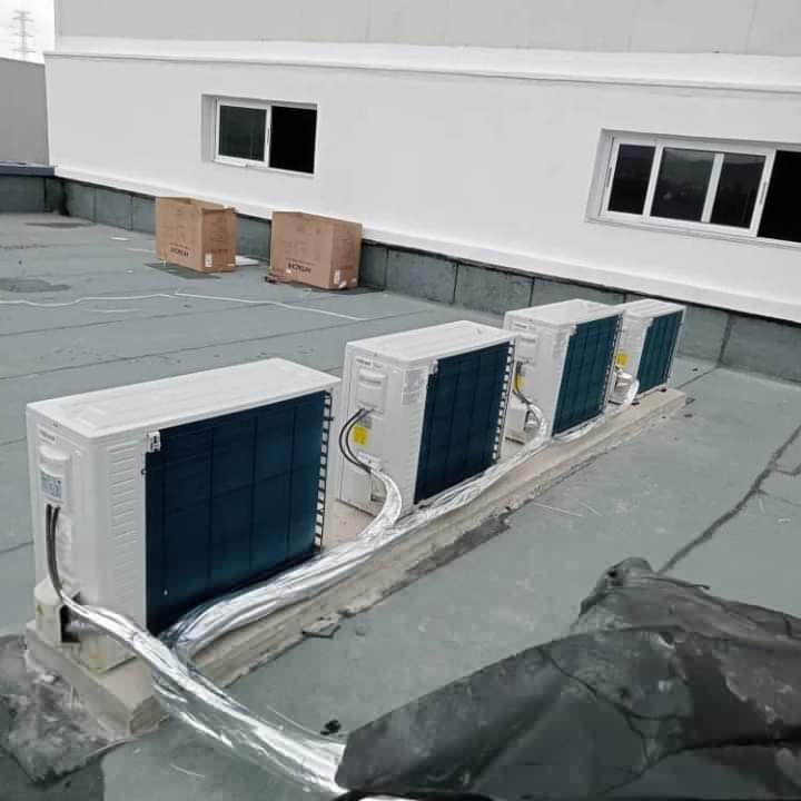 Batterie de quatre unités extérieures de climatisation installées en toiture