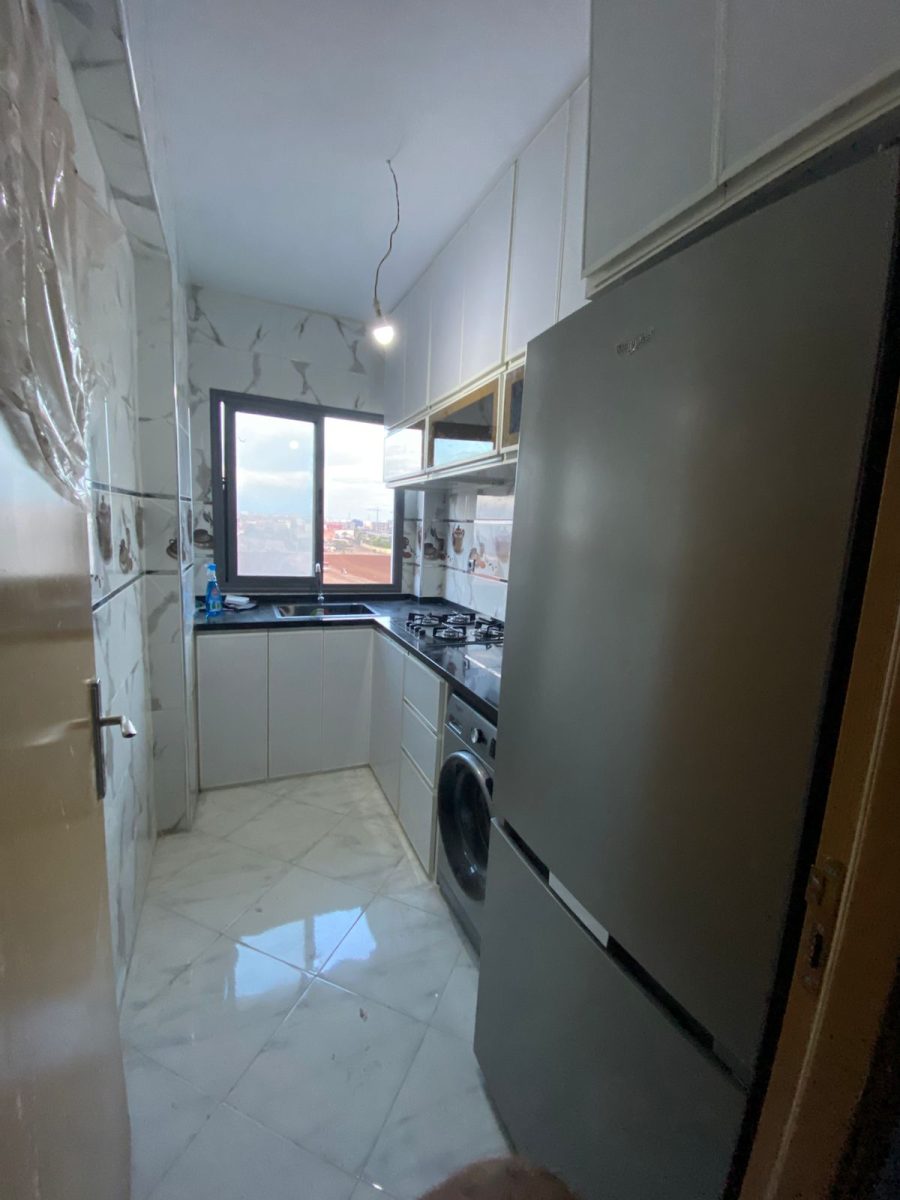 Petite cuisine en aluminium blanc avec plan foncé et vue dégagée