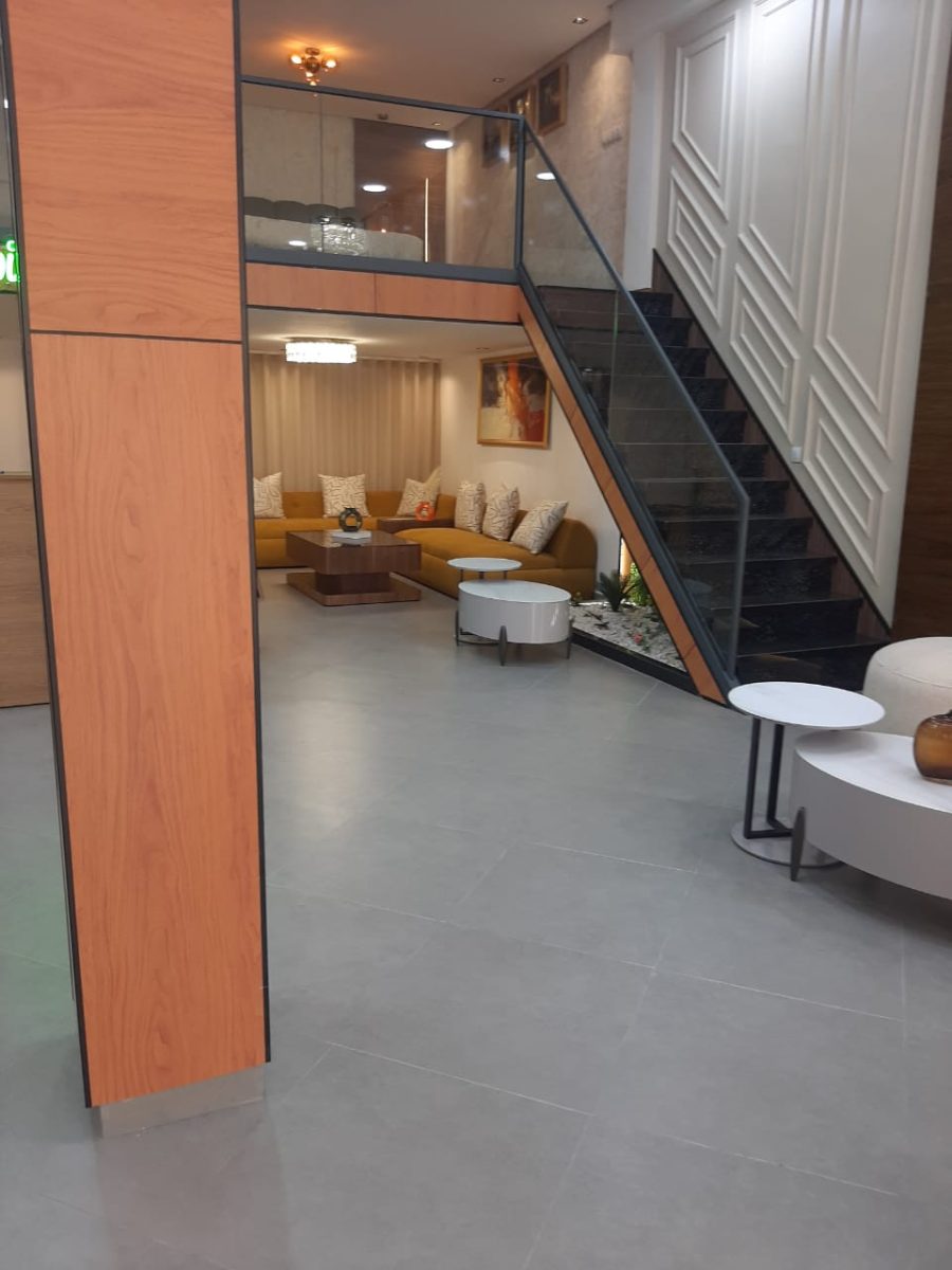 Escalier à garde-corps en verre et habillage bois dans un séjour moderne