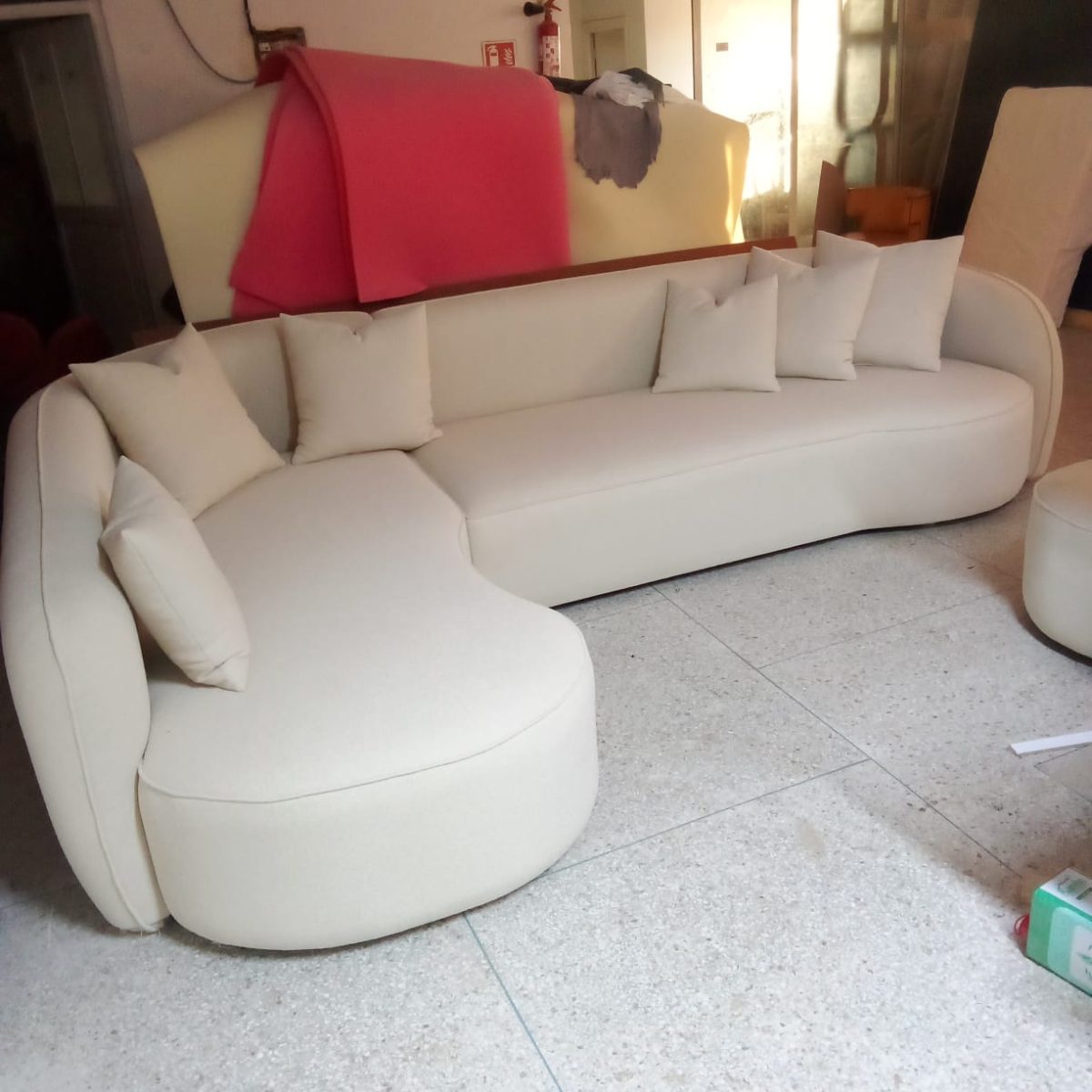 Canapé arrondi sur mesure en tissu crème avec coussins