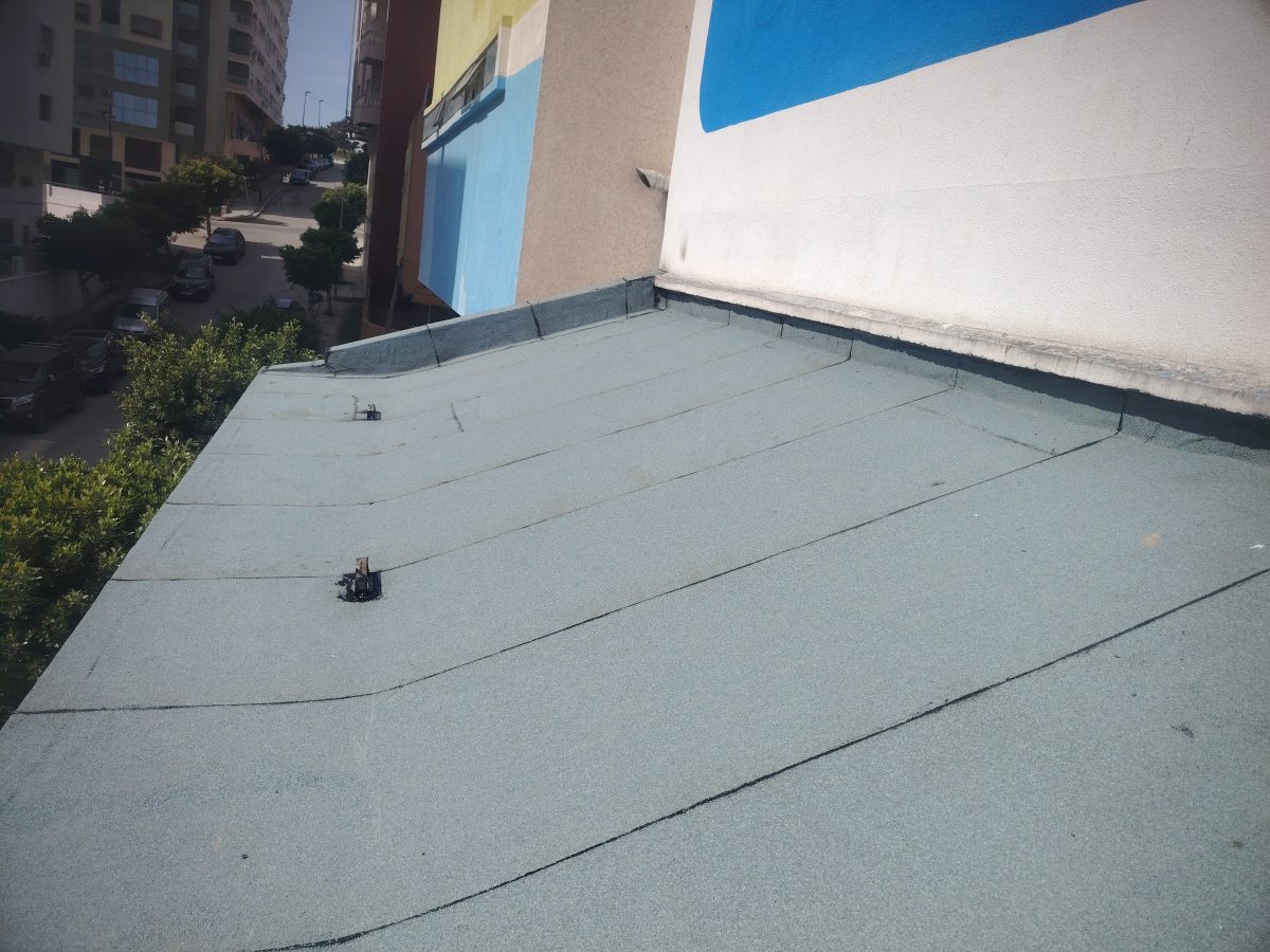 Toiture-terrasse étanchée membrane verte le long d'une façade