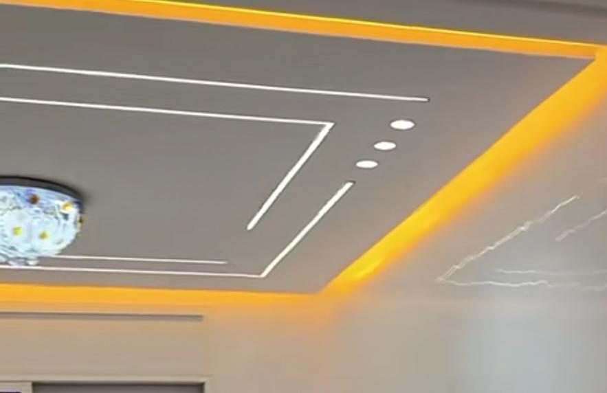 Faux plafond gris à lignes lumineuses LED et gorge jaune