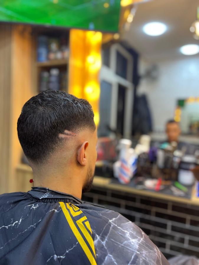 Dégradé net réalisé sur la nuque d'un client dans un barbershop