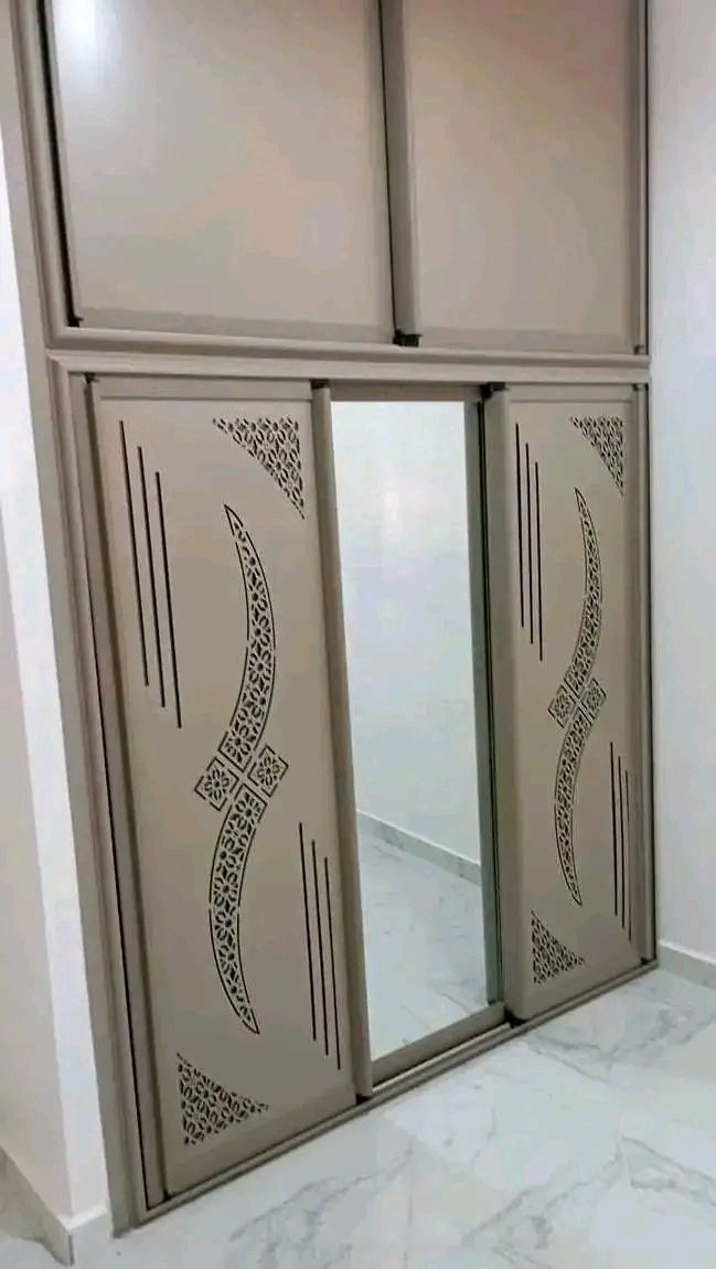 Placard coulissant en aluminium beige à motifs arabesques découpés au laser et miroir