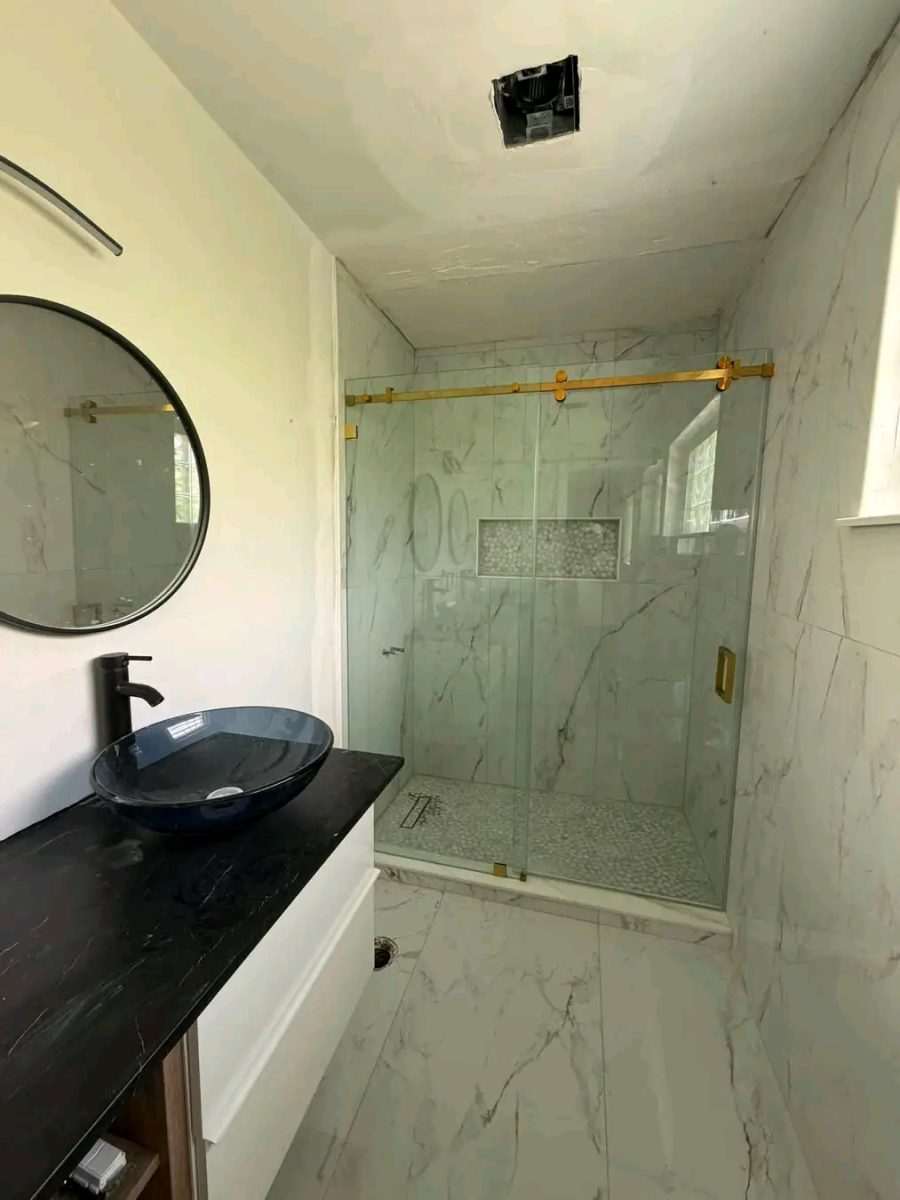 Salle de bain à paroi de douche en verre à rail doré