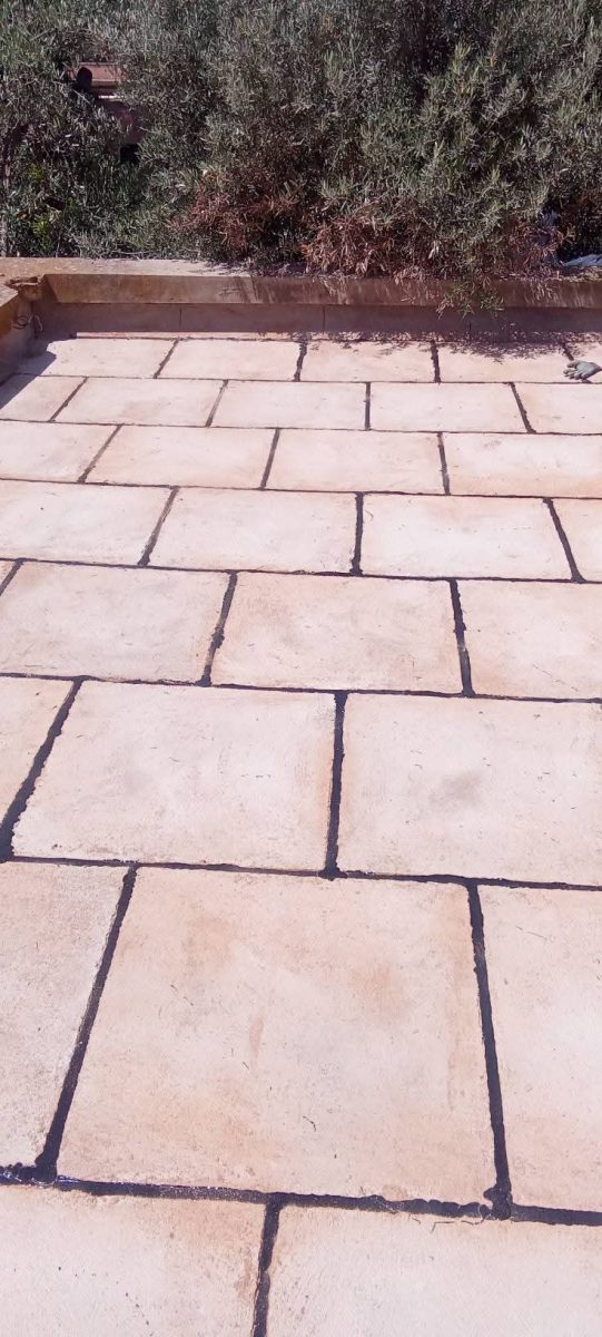 Terrasse revêtue de dalles de pierre beige après étanchéité