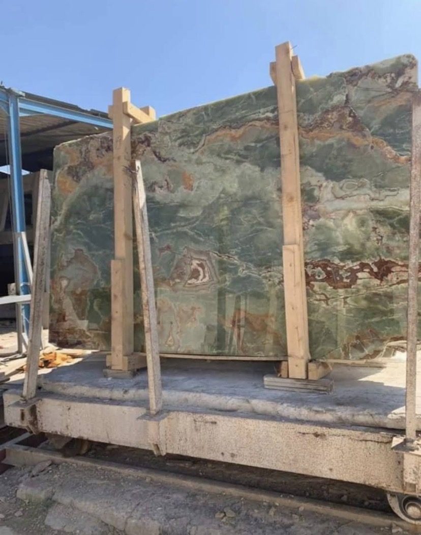 Dalle d'onyx vert veiné calée sur un chariot en dépôt