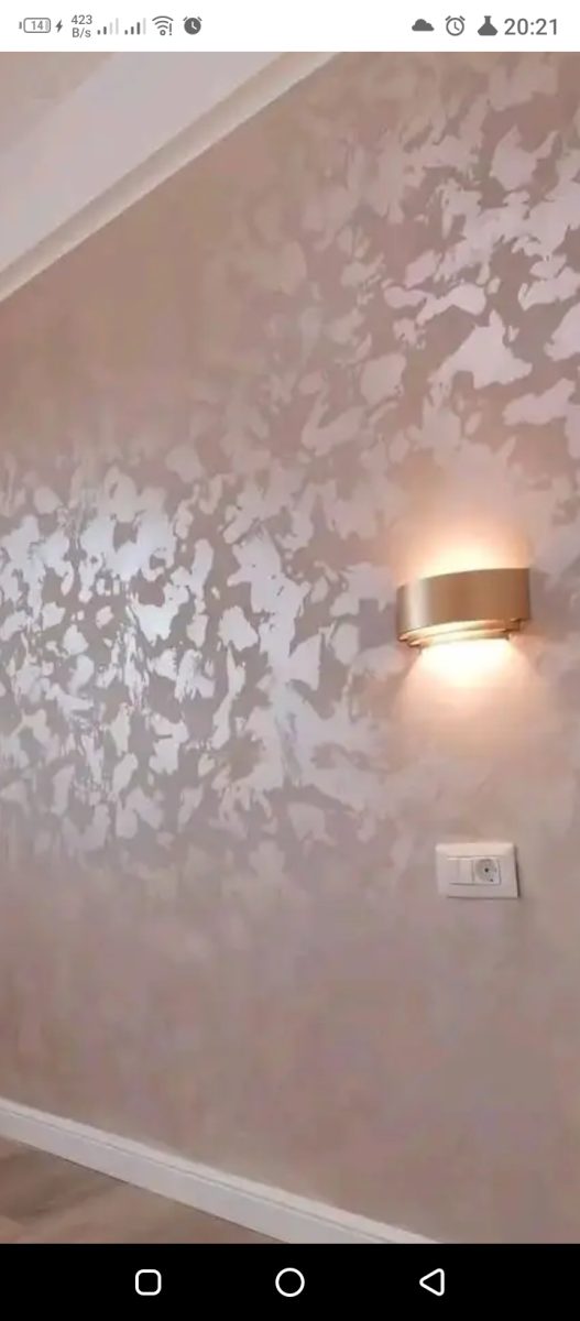Mur en peinture décorative métallisée rose-doré avec applique