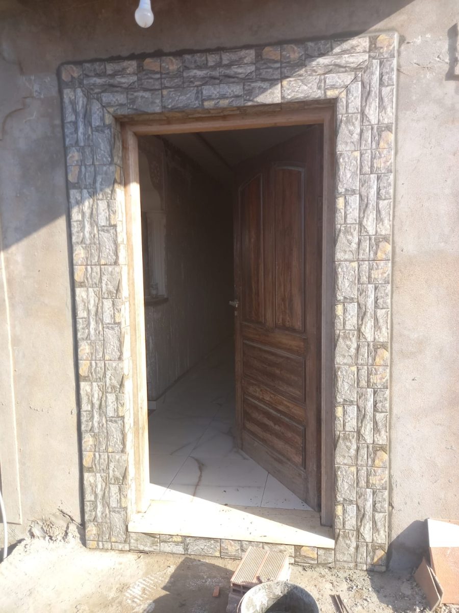 Encadrement de porte d'entrée en carrelage effet pierre grise