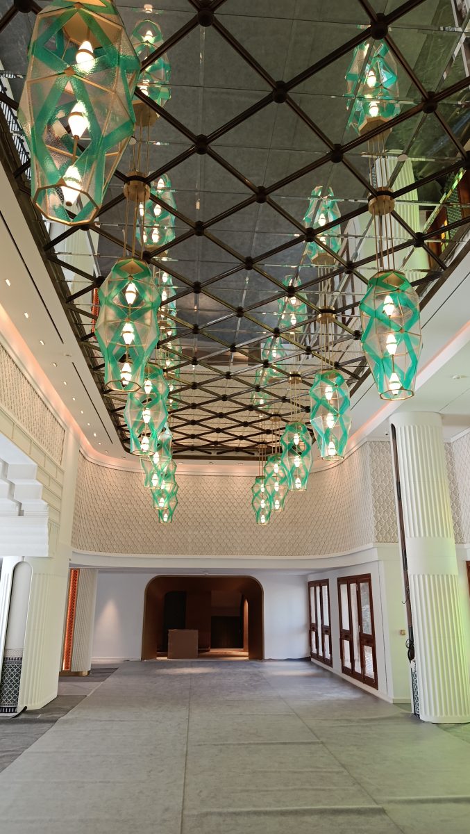 Hall à plafond losange et suspensions en verre vert