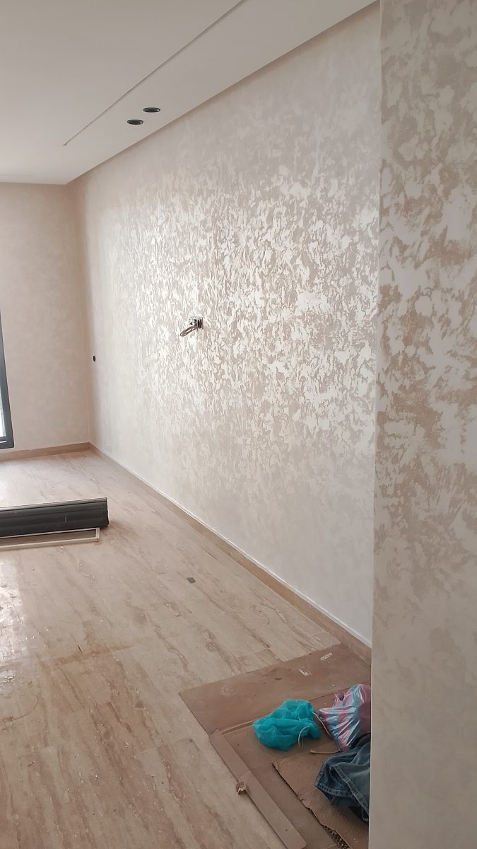 Couloir en enduit décoratif nacré beige-argenté sur sol travertin