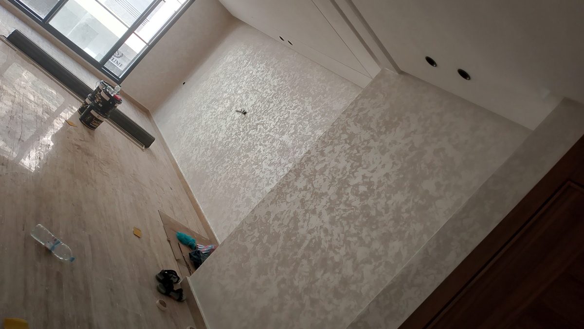 Séjour aux murs en enduit décoratif nacré argenté avec sol en travertin