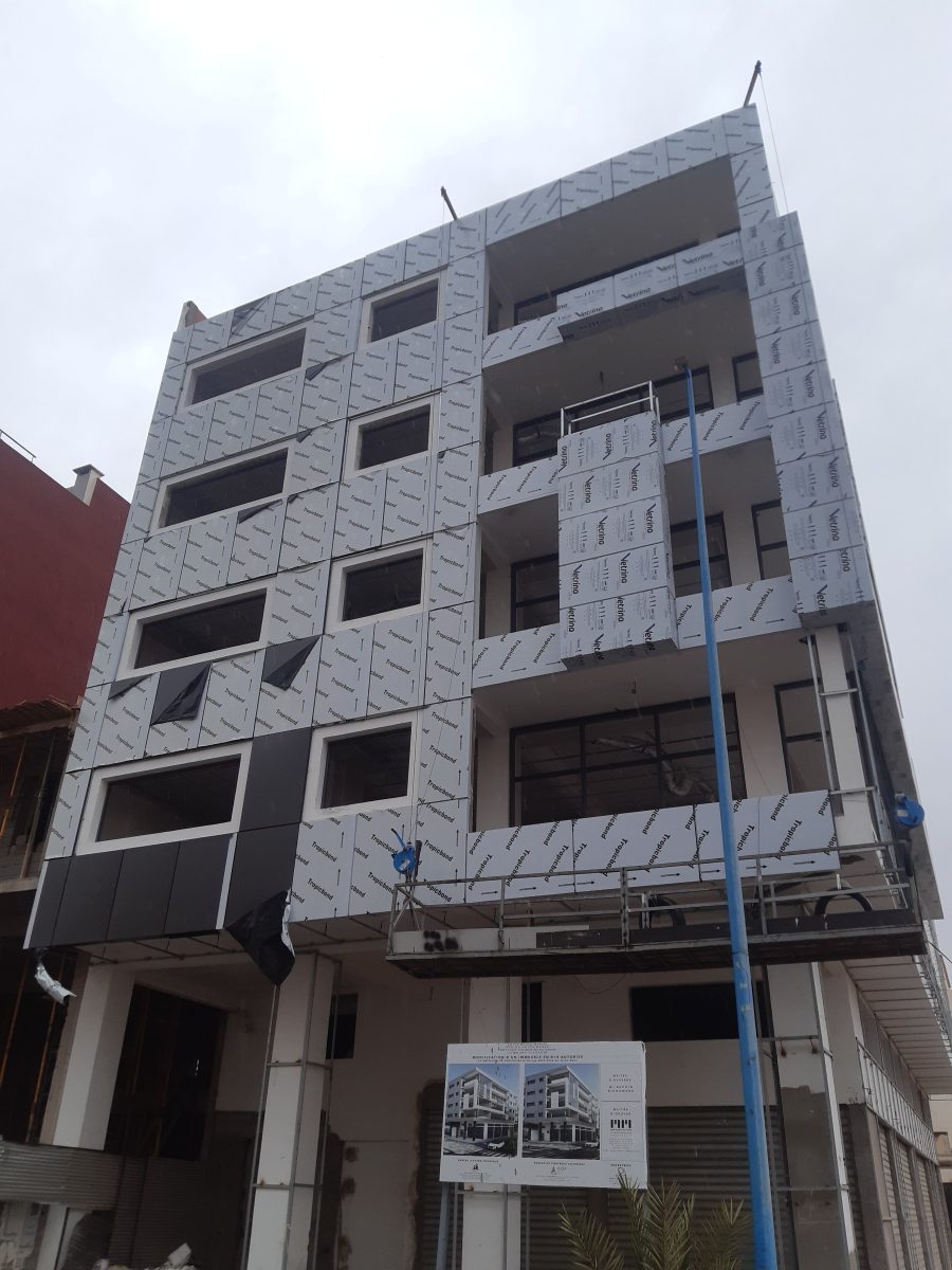 Façade en cours d'habillage en panneaux composites gris