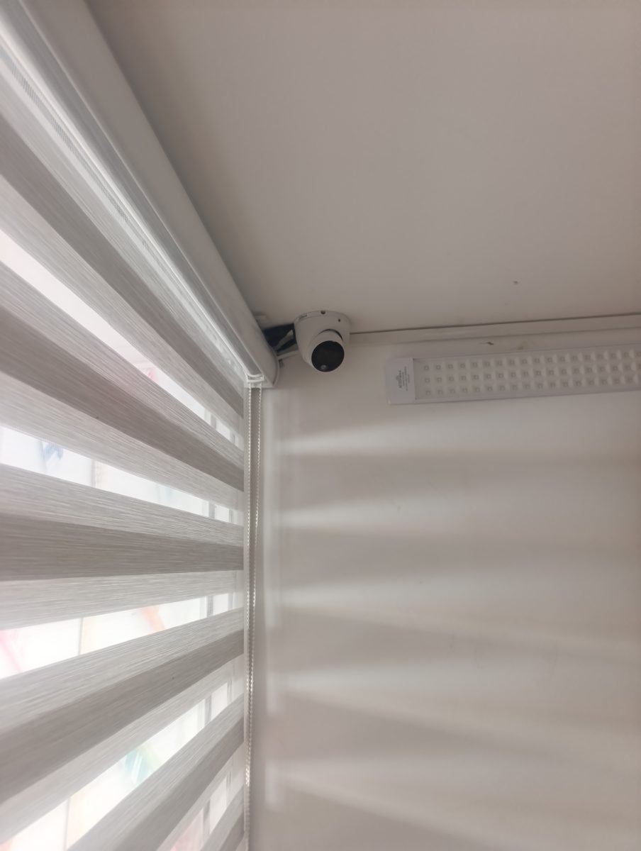 Caméra dôme installée en angle près d'un store jour-nuit