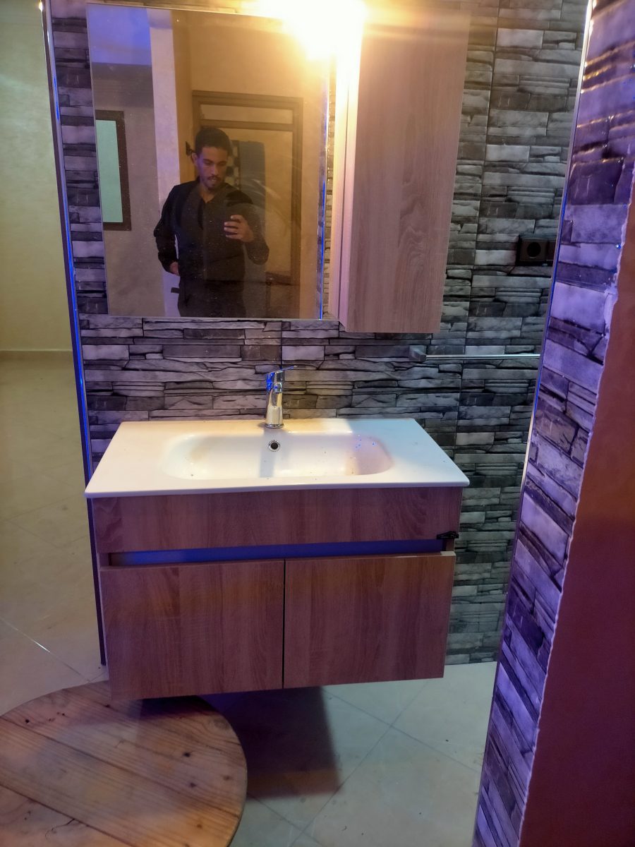 Meuble sous-vasque suspendu avec vasque et miroir sur mur en pierre