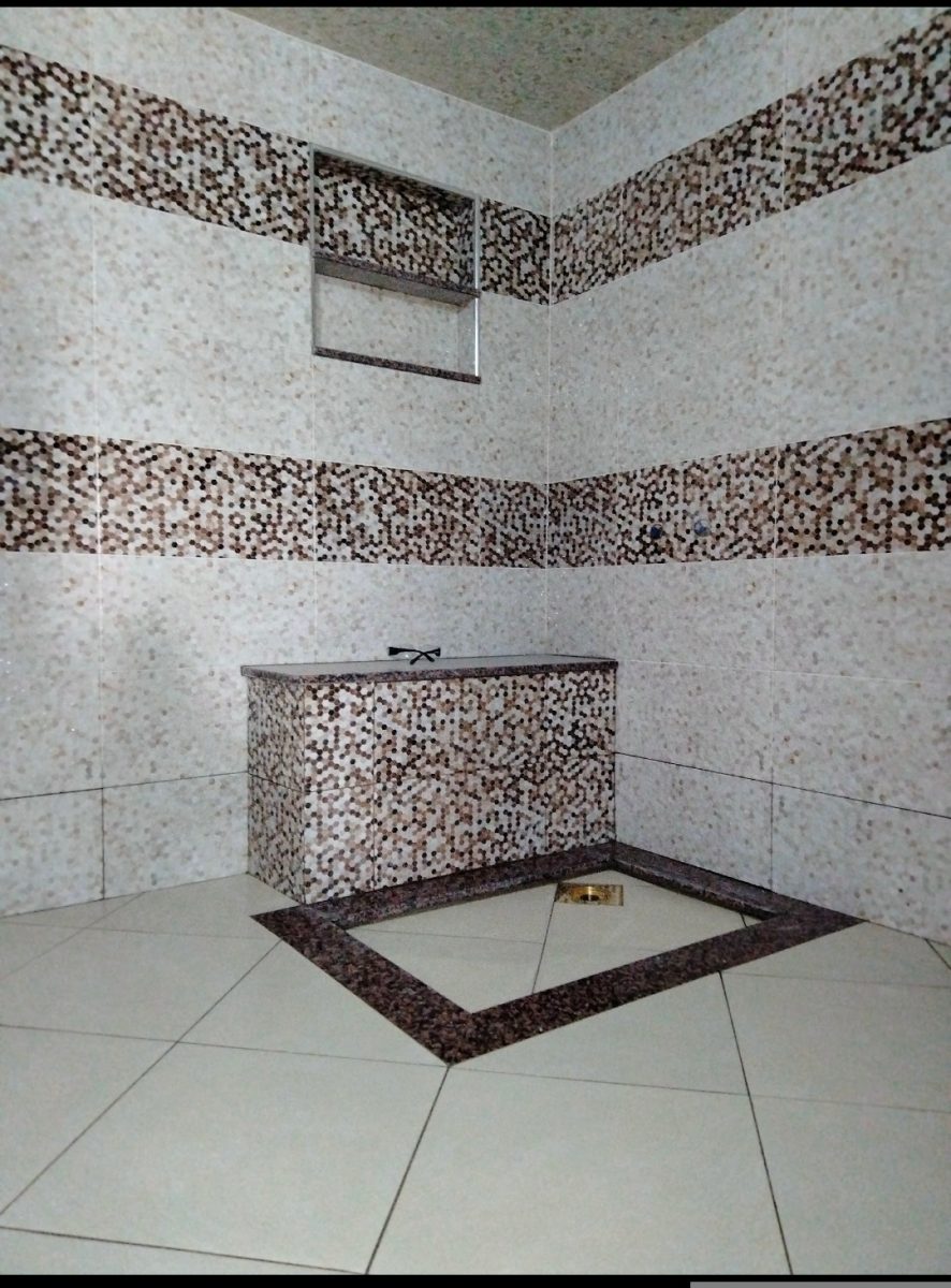 Hammam habillé de mosaïque beige et marron avec banquette
