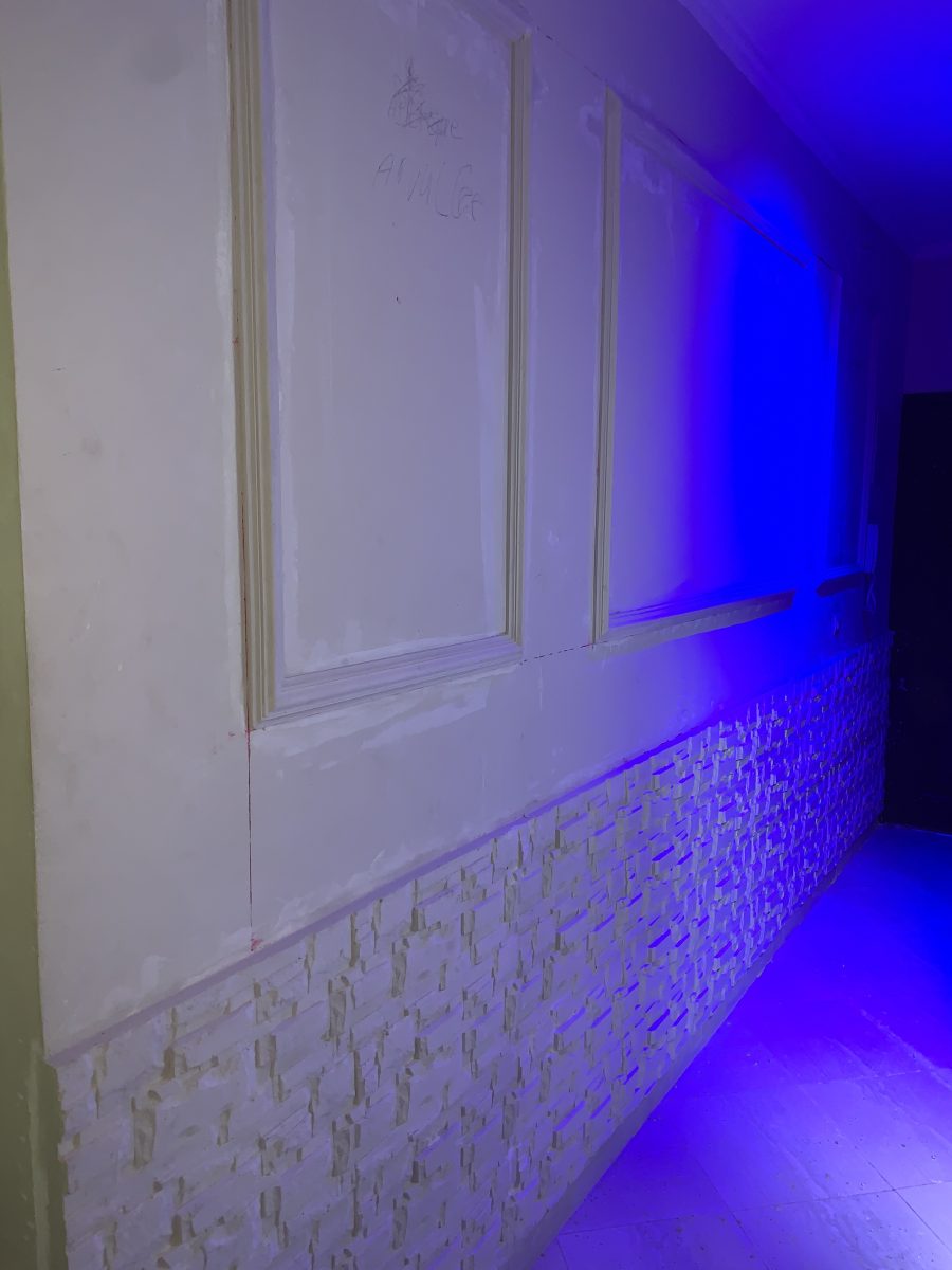 Couloir à soubassement en pierre et moulures en plâtre, en cours
