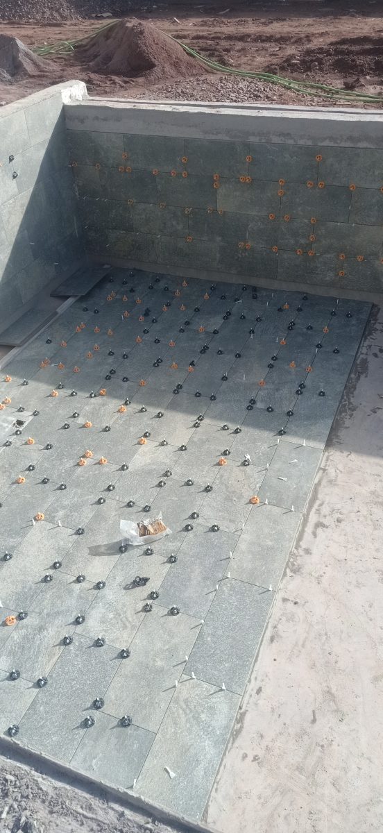 Carrelage d'un bassin extérieur en carreaux gris-vert, en cours
