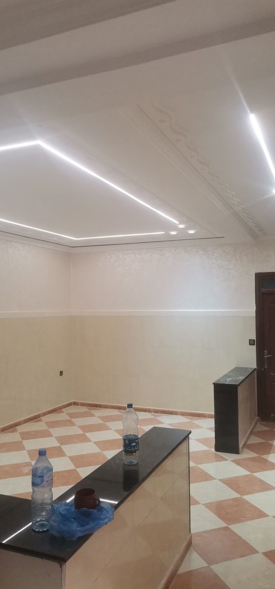 Pièce à faux plafond LED, murs bicolores et sol à damier