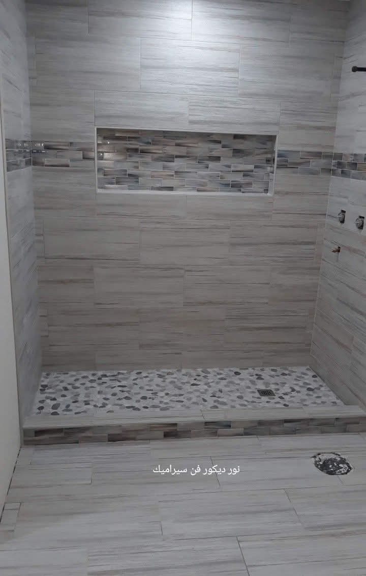 Douche carrelée effet bois-pierre gris avec niche mosaïque et galets