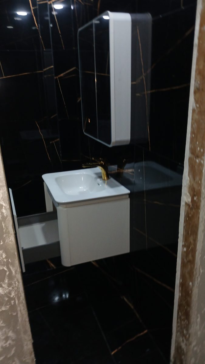 Salle d'eau en faïence effet marbre noir avec meuble-vasque blanc