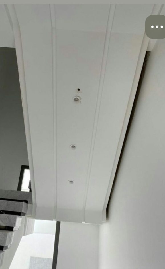Retombée de faux plafond en plâtre à spots dans une cage d'escalier