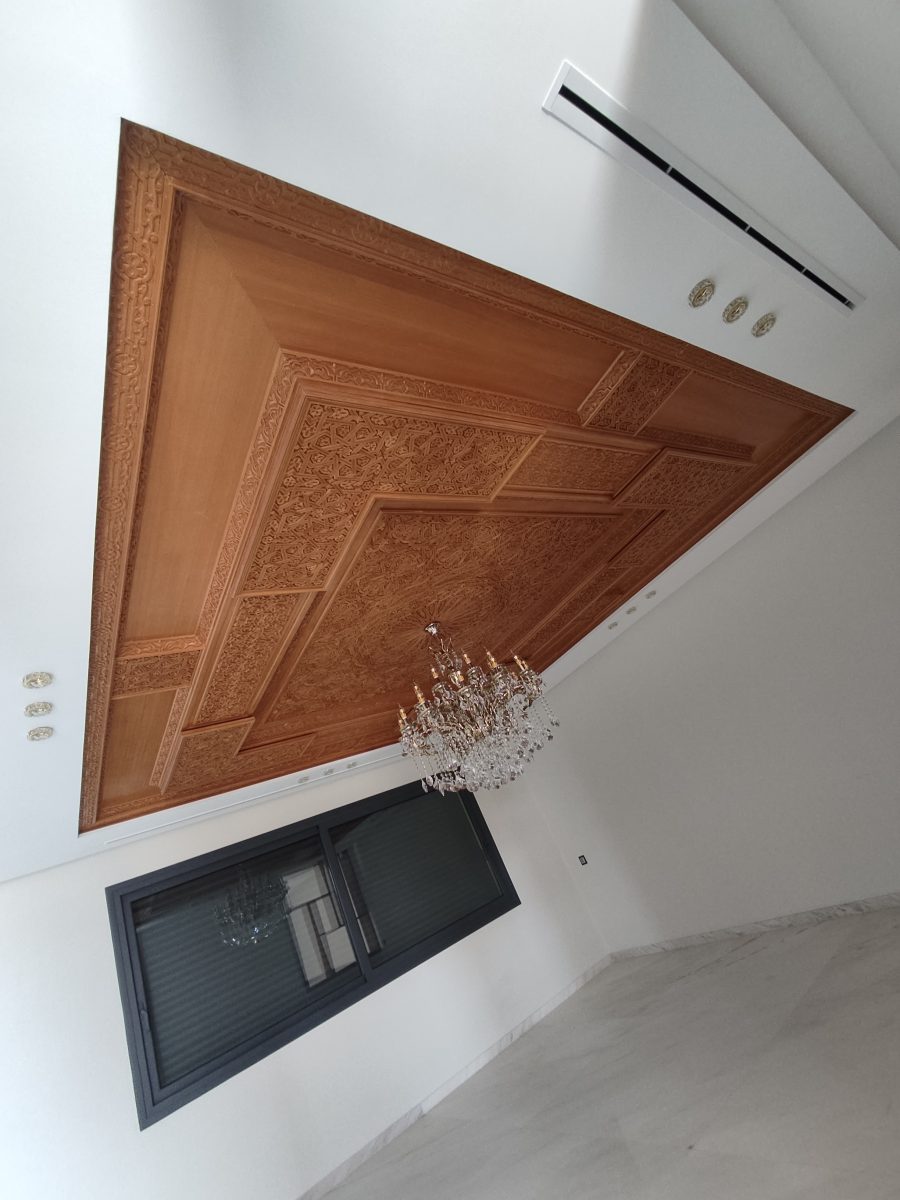 Plafond en panneaux de bois sculptés à motifs arabes avec lustre