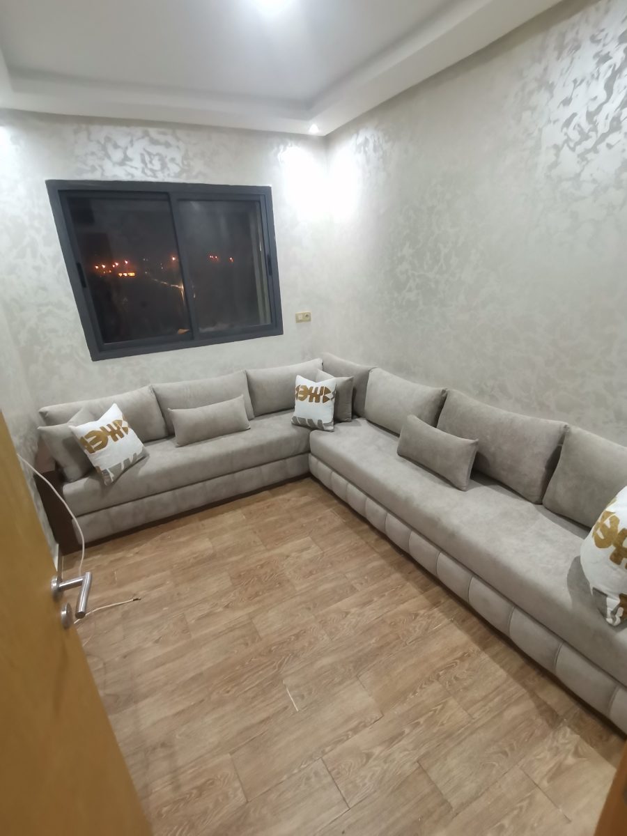 Salon marocain d'angle tapissé en velours gris avec coussins