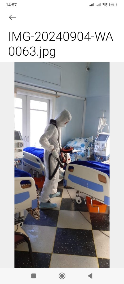 Agent en combinaison désinfectant une chambre d'hôpital
