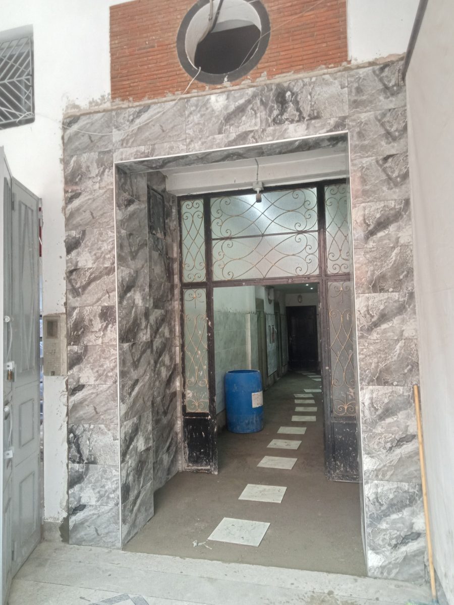 Hall d'immeuble en effet marbre à porte en ferronnerie