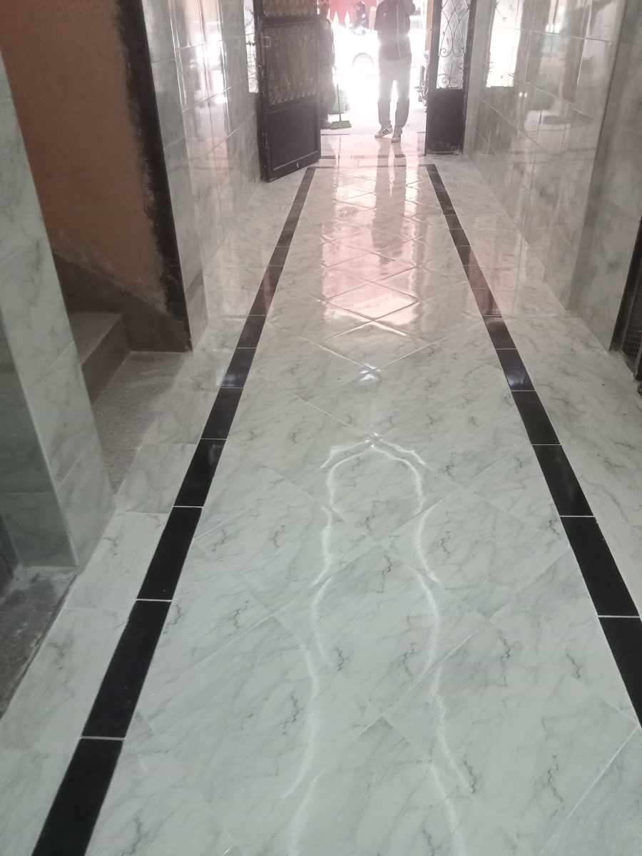 Couloir au sol en carrelage effet marbre blanc
