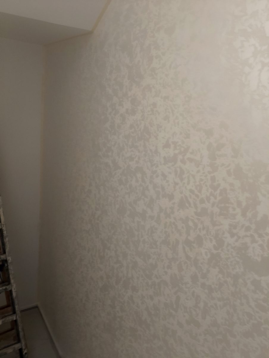 Mur d'angle en peinture décorative nacrée beige clair, en cours