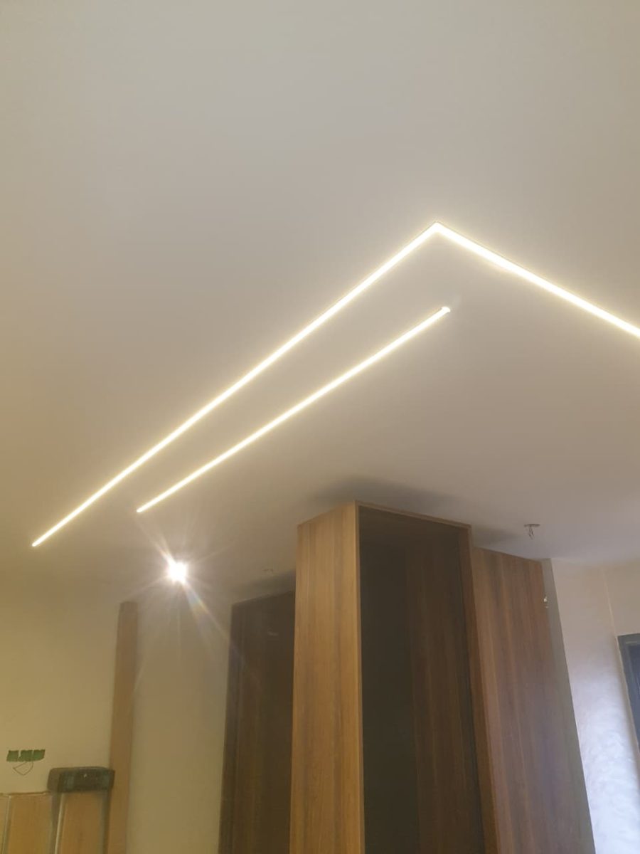 Faux plafond à lignes lumineuses LED en L avec colonnes en bois