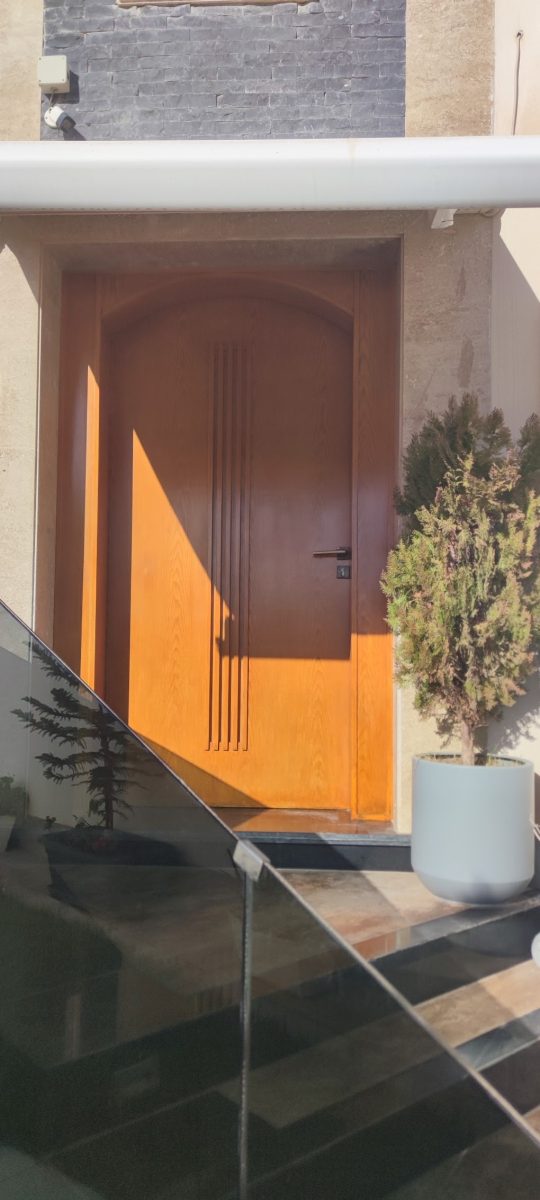 Porte d'entrée cintrée en bois vernis à cannelures