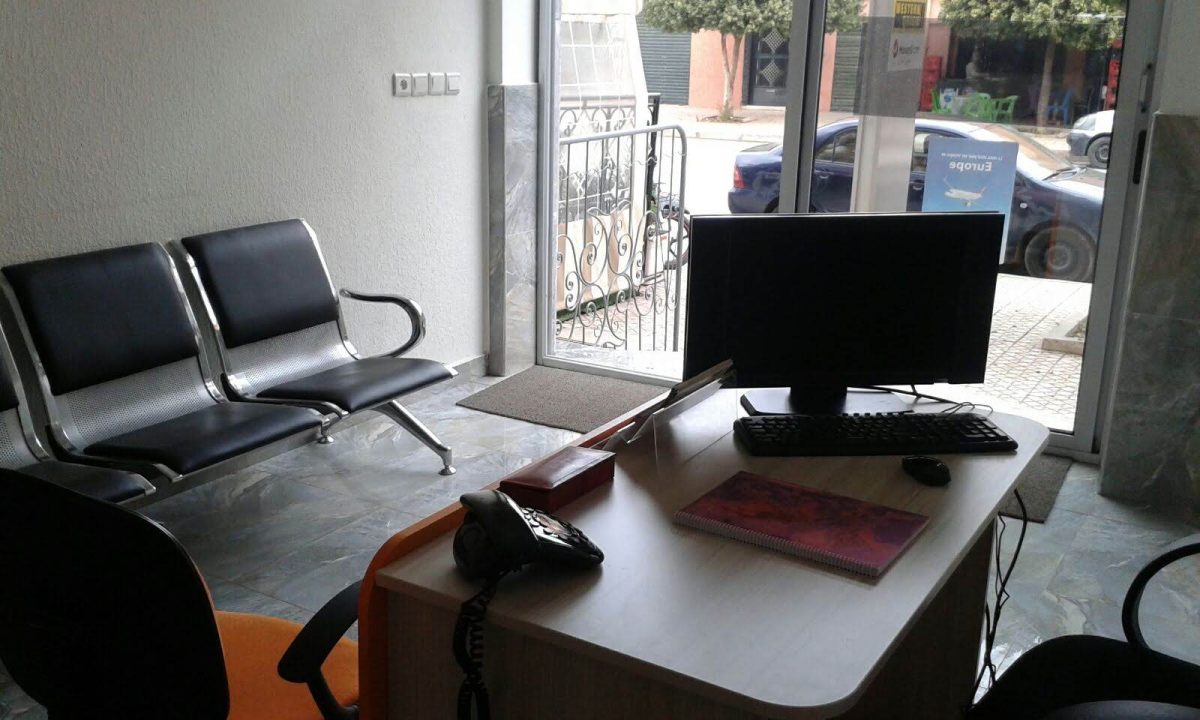 Bureau d'agence avec poste informatique et banquette d'attente