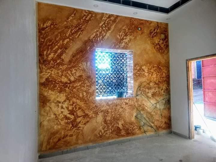 Mur en peinture effet marbre ocre-doré autour d'une niche à claustra
