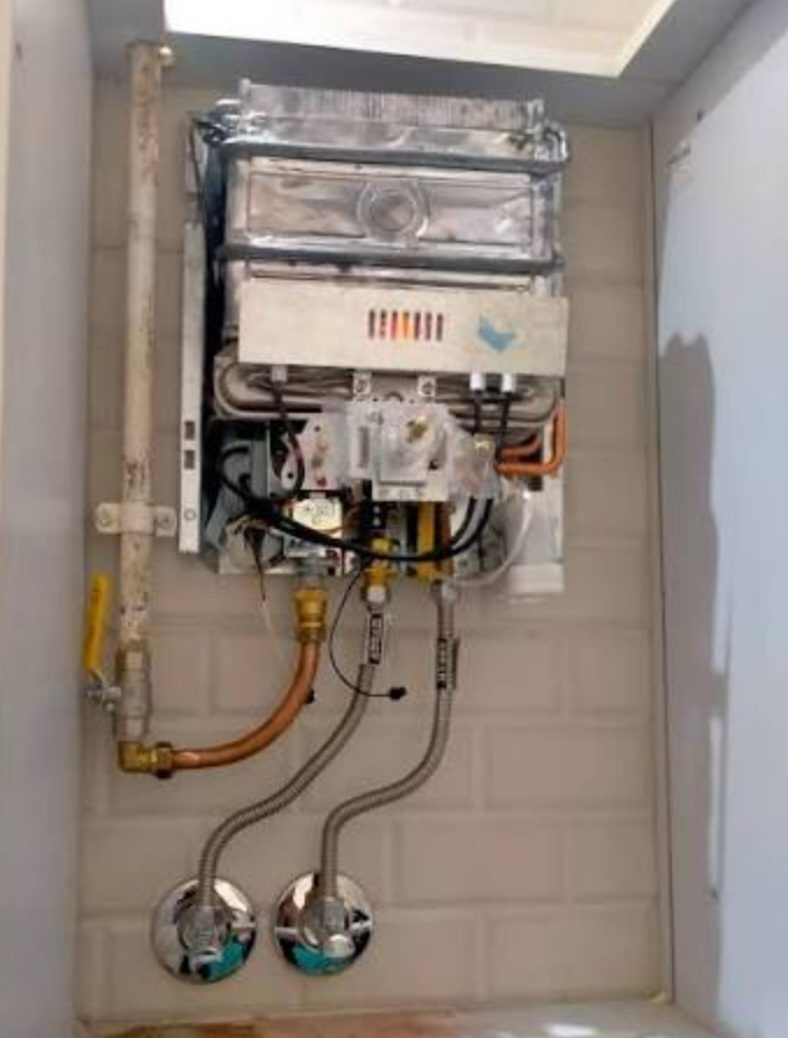 Chauffe-eau à gaz mural raccordé dans une niche carrelée