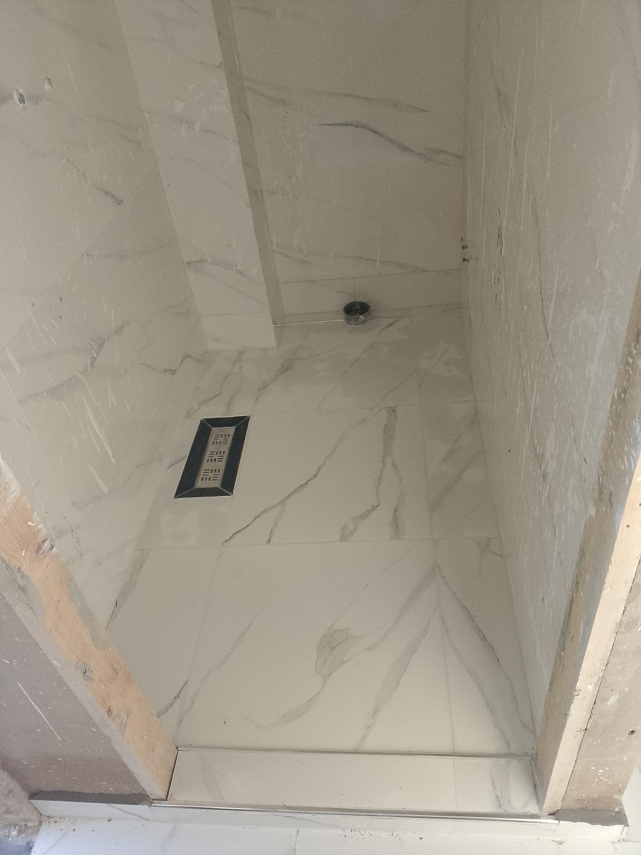 Douche à l'italienne carrelée effet marbre avec caniveau décoratif