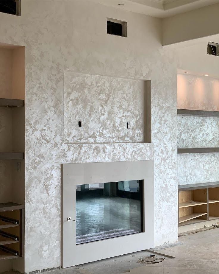 Mur à cheminée en enduit décoratif effet nuage argenté et niches